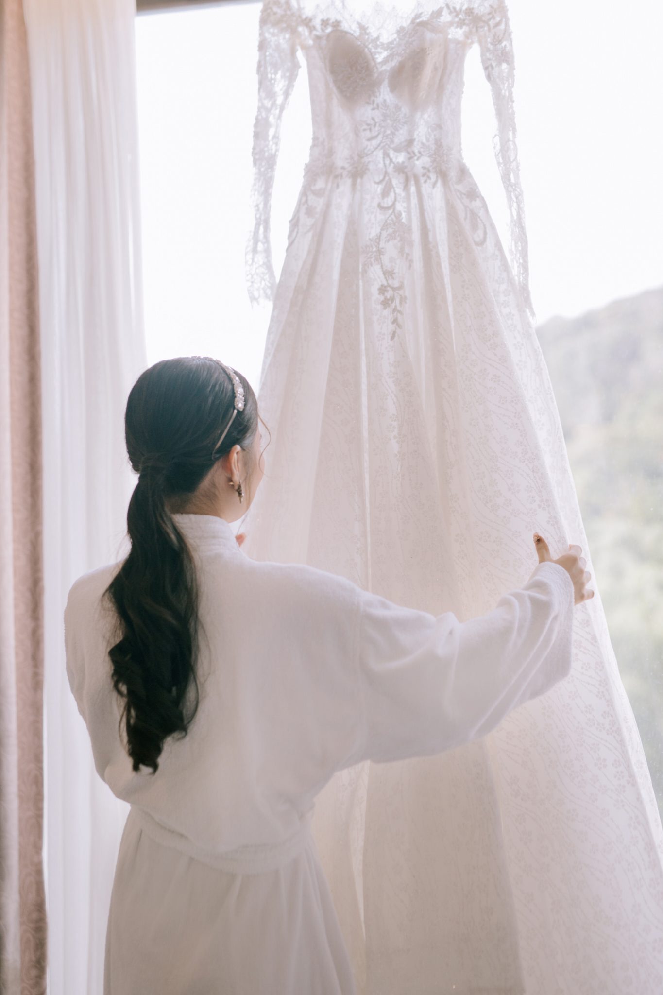 Chúng tôi đã xây dựng một quy trình 5 bước tinh gọn và hiệu quả để đảm bảo hành trình thiết kế váy cưới từ xa của bạn diễn ra suôn sẻ, dễ dàng và đầy cảm hứng. Bước 1: Trò Chuyện Cùng Nhà Thiết Kế Thanh Tú (Tư Vấn 1:1 Online) Mọi kiệt tác đều bắt đầu từ một cuộc trò chuyện. Qua buổi video call đầu tiên, chúng ta sẽ cùng nhau chia sẻ về câu chuyện tình yêu, phong cách cá nhân, chủ đề đám cưới và những ý tưởng ban đầu của bạn. Từ đó, NTK Thanh Tú sẽ tư vấn về phom dáng, chất liệu và bắt đầu phác thảo những bản vẽ đầu tiên dành riêng cho bạn. Bước 2: Lấy Số Đo Hoàn Hảo (Hướng Dẫn Chi Tiết) Đây là bước quan trọng nhất và cũng là điều các cô dâu lo lắng nhất. Đừng lo, chúng tôi có một quy trình cực kỳ chi tiết: Green sẽ gửi bạn một video và một file hướng dẫn đo 15 chỉ số cơ thể quan trọng. Chúng ta sẽ có một buổi video call thứ hai, nơi đội ngũ của Green sẽ trực tiếp hướng dẫn bạn hoặc người thân của bạn cách lấy số đo một cách chính xác nhất. Bước 3: Từ Bản Vẽ Đến Tà Váy (Cập Nhật Trực Quan) Sau khi thống nhất bản vẽ và số đo, các nghệ nhân của Green sẽ bắt đầu quá trình chế tác. Bạn sẽ được cập nhật tiến độ liên tục qua hình ảnh và video thực tế: từ việc chọn vải, cắt rập, dựng phom corset cho đến những chi tiết đính kết đầu tiên. Bạn sẽ được chứng kiến chiếc váy của mình hình thành mỗi ngày. Bước 4: Thử Váy Lần Đầu & Tinh Chỉnh (Fitting) Khi chiếc váy đã hoàn thiện khoảng 80-90%, chúng tôi sẽ gửi váy đến cho bạn để tiến hành thử phom dáng lần đầu tiên (fitting phom mộc). Qua video call, chúng tôi sẽ cùng bạn kiểm tra và ghi nhận lại tất cả những điểm cần tinh chỉnh cuối cùng để đảm bảo chiếc váy vừa vặn hoàn hảo. Đối với các cô dâu có thể sắp xếp về Việt Nam, chúng tôi sẽ ưu tiên lịch hẹn để hoàn thiện váy trực tiếp tại showroom. Bước 5: Bàn Giao Kiệt Tác Chiếc váy cưới hoàn thiện sẽ được kiểm tra chất lượng lần cuối, giặt hấp chuyên nghiệp, và đóng gói cẩn thận trong hộp đựng sang trọng để vận chuyển đến tận tay bạn, dù bạn ở bất cứ nơi đâu trên thế giới.